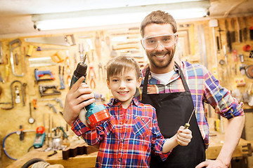 Image showing father and son with drill working at workshop