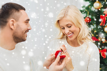 Image showing man giving woman engagement ring for christmas