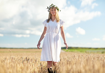 Image showing happy young woman in flower wreath on cereal field