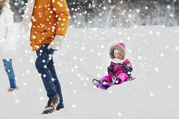 Image showing happy family with sled walking in winter forest