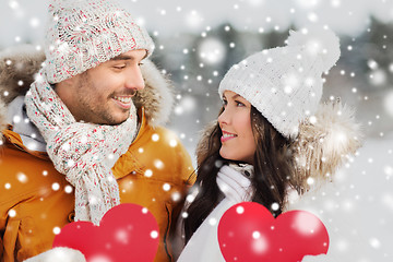 Image showing happy couple with red hearts over winter landscape