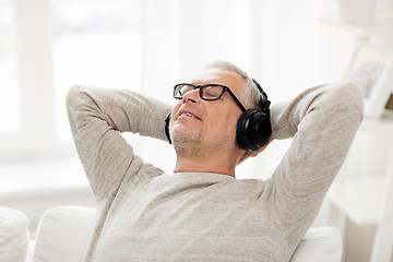 Image showing happy man in headphones listening to music at home