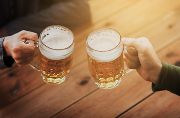 Image showing close up of hands with beer mugs at bar or pub