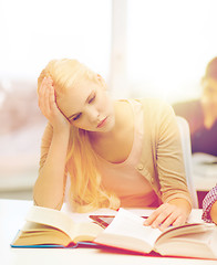 Image showing tired teenage student with tablet pc and books