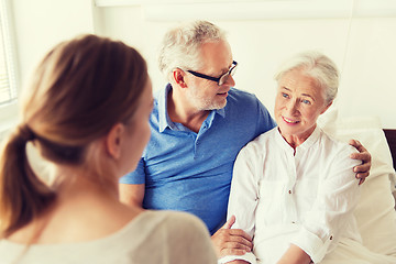 Image showing happy family visiting senior woman at hospital