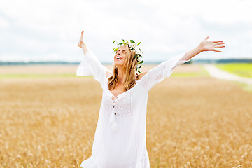 Image showing happy young woman in flower wreath on cereal field