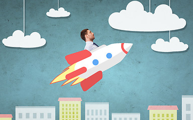 Image showing businessman flying on rocket above cartoon city