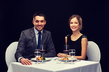 Image showing smiling couple eating main course at restaurant