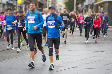 Image showing Marathon runners race in city streets, blurred motion