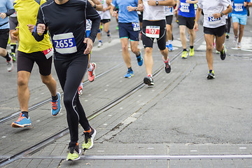 Image showing Marathon runners race in city streets, blurred motion