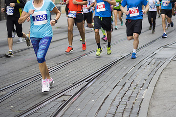 Image showing Marathon runners race in city streets, blurred motion