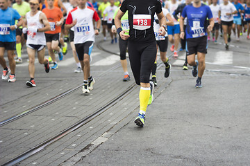 Image showing Marathon runners race in city streets, blurred motion