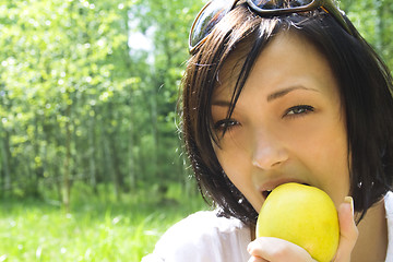 Image showing young happy woman eating apple