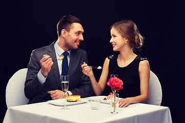 Image showing smiling couple eating dessert at restaurant