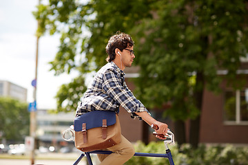 Image showing young hipster man with bag riding fixed gear bike