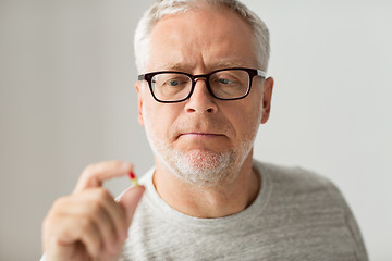 Image showing close up of senior man taking medicine pill