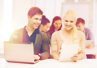 Image showing two smiling students with laptop and tablet pc