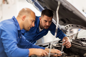 Image showing mechanic men with wrench repairing car at workshop