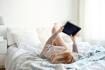 Image showing happy young woman with tablet pc in bed at home