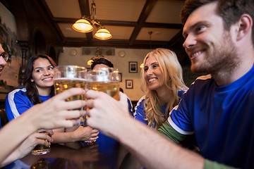 Image showing football fans clinking beer glasses at sport bar