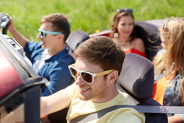 Image showing happy friends driving in cabriolet car outdoors