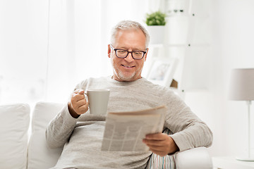 Image showing senior man in glasses reading newspaper at home