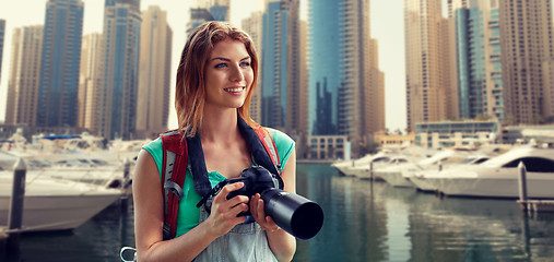 Image showing woman with backpack and camera over dubai city