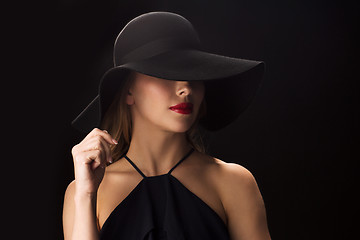 Image showing beautiful woman in black hat over dark background