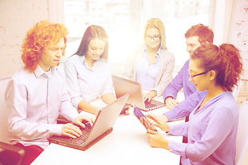 Image showing smiling team with laptop and table pc computers