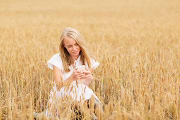 Image showing happy woman with smartphone and earphones