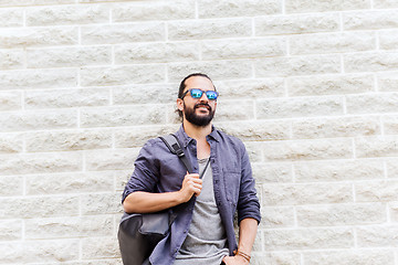 Image showing man with backpack standing at city street wall