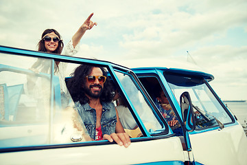 Image showing smiling young hippie friends over minivan car