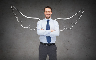 Image showing happy businessman with angel wings over gray