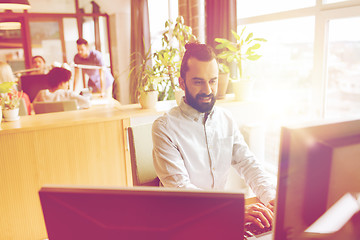 Image showing happy creative male office worker with computer