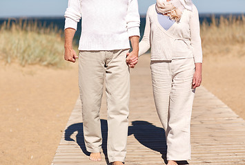 Image showing close up of senior couple walking on summer beach