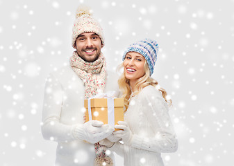 Image showing smiling couple in winter clothes with gift box