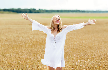 Image showing smiling young woman in white dress on cereal field