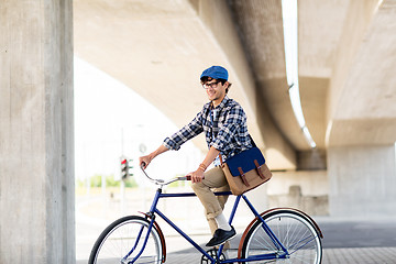 Image showing happy hipster man with bag riding fixed gear bike