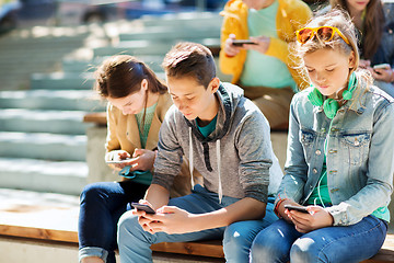 Image showing teenage friends with smartphones outdoors