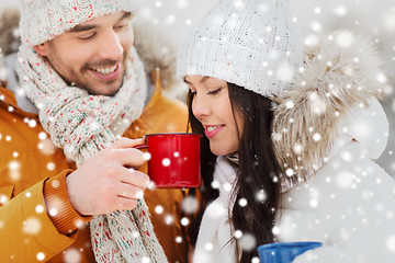 Image showing happy couple with tea cups over winter landscape