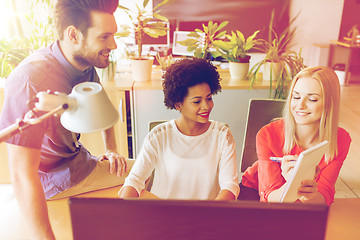 Image showing happy creative team with computer in office