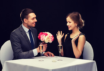 Image showing smiling man giving flower bouquet to woman