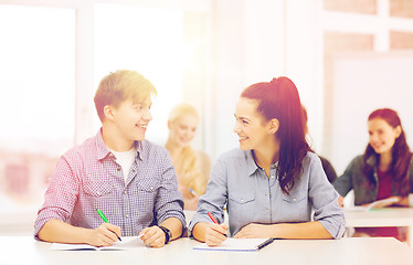 Image showing two teenagers with notebooks at school