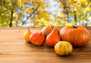 Image showing close up of pumpkins on wooden table outdoors
