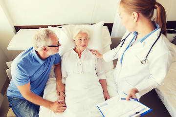 Image showing senior woman and doctor with clipboard at hospital