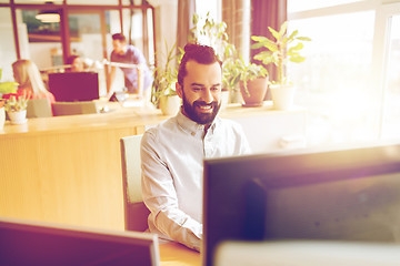 Image showing happy creative male office worker with computer