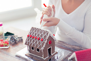 Image showing close up of woman making gingerbread house at home