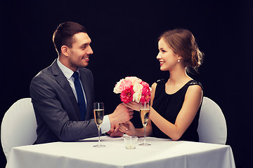 Image showing smiling man giving flower bouquet to woman