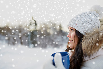 Image showing happy young woman with tea cup outdoors in winter