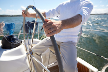 Image showing senior man at helm on boat or yacht sailing in sea